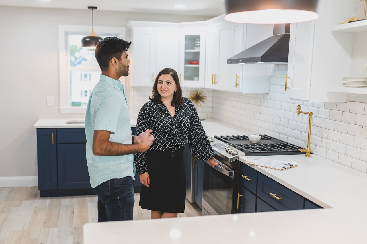 Couple exploring a modern kitchen space during a real estate tour.