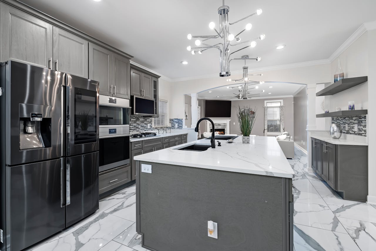 Sleek modern kitchen design featuring stainless steel appliances, marble countertops, and elegant lighting.