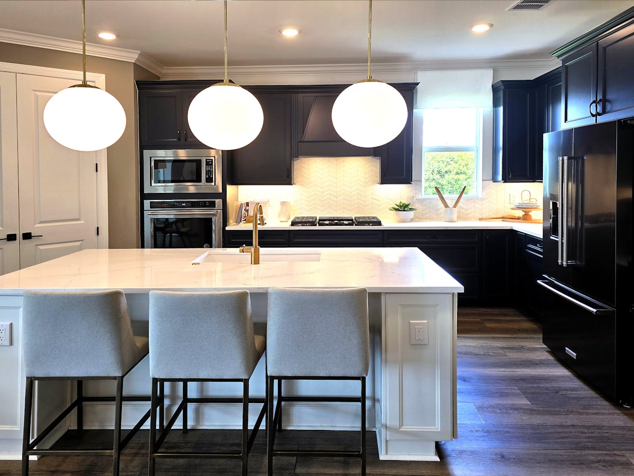 Sleek kitchen design featuring an island, pendant lights, and contemporary appliances.